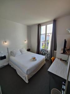 滨海苏拉克Hôtel Michelet Plage的卧室设有一张白色大床和一扇窗户。