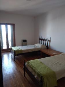 乌拉圭河畔康塞普西翁Departamento Rocamora的一间卧室设有两张床,铺有木地板