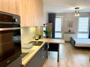 罗兹Platon Residence Apartments的一个带书桌的厨房和一张位于客房内的床
