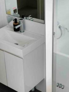 悉尼2Bedrooms 2Bathrooms Oasis in Parramatta w parking的浴室设有白色水槽和镜子