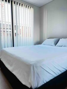 悉尼2Bedrooms 2Bathrooms Oasis in Parramatta w parking的卧室内的一张白色床,设有窗户