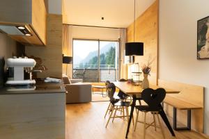 施勒肯Heimat 1495m Appartement TYP 2的厨房以及带桌椅的起居室。