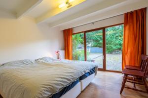 拉罗什-阿登Au Ptit Bois Charmant的一间卧室设有一张床和一个大窗户