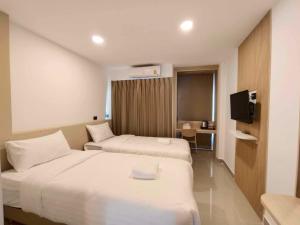 武里南SNOW HOUSE Buriram的酒店客房设有两张床和电视。