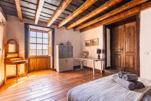 比拉夫洛尔Casa Argelia的一间卧室配有一张床铺、一张桌子和一台冰箱