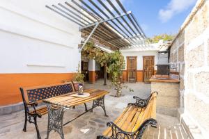 比拉夫洛尔Casa Argelia的庭院设有2张长椅和木桌