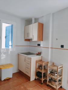 拉伊斯莱塔德尔摩洛Pita 2的厨房设有白色的墙壁和木制橱柜。