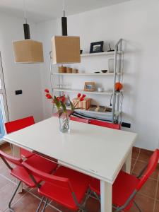 拉伊斯莱塔德尔摩洛Pita 2的客房内的一张带红色椅子的白色桌子