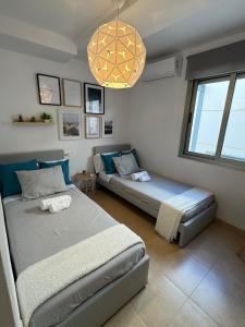 卡沃内拉斯Apartamento Cervantes con terraza y vistas al mar的一间卧室配有两张床、一张沙发和一个吊灯。