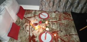 伊丽莎白港Kingsworth inn Port Elizabeth的床上的桌子,上面放着食物和蜡烛