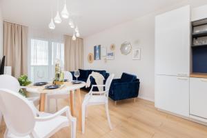 格但斯克Apartment Sucha Nowa Letnica by Renters的厨房以及带桌椅的起居室。