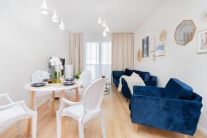 格但斯克Apartment Sucha Nowa Letnica by Renters的客厅配有桌子和蓝色沙发