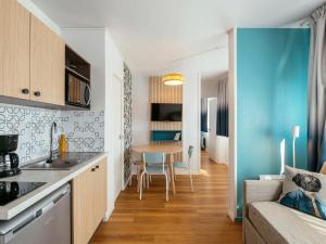 巴黎巴黎拉维莱特阿德吉奥阿克瑟斯公寓酒店的厨房以及带桌子和沙发的客厅。