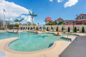 大洋城Comfort Suites Ocean City West的一个带椅子和棕榈树的度假村游泳池