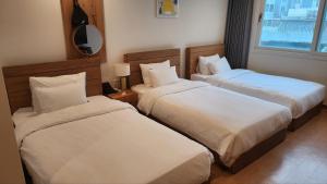 西归浦市Heyy Seogwipo Hotel的酒店客房,设有两张床和镜子