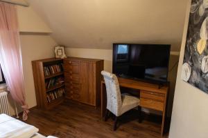 恩斯塔尔豪斯apartHAUS的一间卧室配有一张桌子、一台电视和一把椅子
