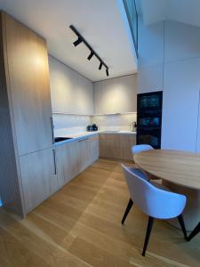 伏尔塔瓦河畔利普诺Molo Lipno apartmán B232的厨房配有木桌和白色橱柜。