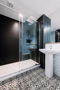 格拉斯哥SmartSleep Apartments的一间带玻璃淋浴和水槽的浴室