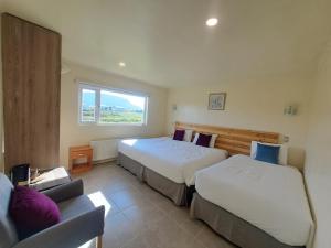 纳塔列斯港Hotel Casa Verde的一间卧室设有两张床、一张沙发和一个窗口