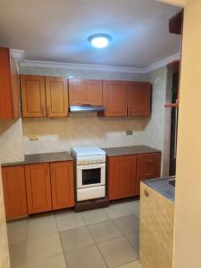 基加利Freedom Homes Kigali的厨房配有木制橱柜和炉灶。
