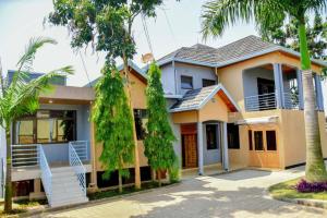 基加利Freedom Homes Kigali的前面有棕榈树的房子