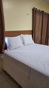 PortelSaymon Hotel的一张带白色床单和枕头的床