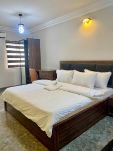 拉各斯MOK Apartments & Suites的一间卧室配有一张带白色床单的大床