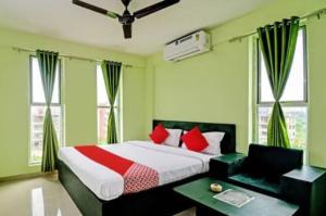 PānchuriaGoroomgo Green Oasis Inn Kolkata的一间卧室配有红色枕头的床