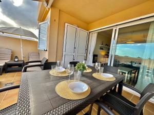 波里斯-德阿沃纳Apartamento Vista Faro的阳台配有带椅子和遮阳伞的餐桌