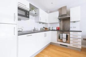 布里斯托Contemporary 1BD Flat - Bristol City Centre!的厨房配有白色橱柜和炉灶。