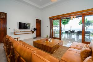 新加拉惹Bali Taoka Beach Villa的带沙发和咖啡桌的客厅