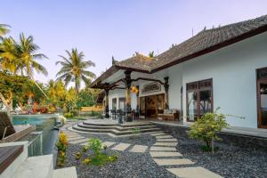 新加拉惹Bali Taoka Beach Villa的一座带游泳池和房子的别墅