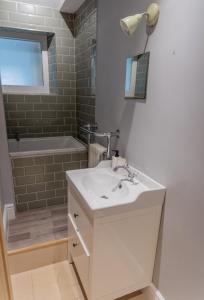 灵顿Stunning period cottage的浴室配有盥洗盆和浴缸。