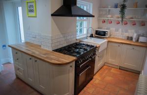 灵顿Stunning period cottage的厨房配有炉灶和水槽