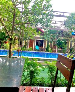 Vũ LâmTAM COC SUNRISE HOMESTAY (VÂN VIỄN, đội 2)的享有带游泳池和长凳的房子的景色