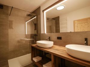 施皮斯Holiday Home bergGLÜCK by Interhome的浴室设有2个水槽、镜子和浴缸。