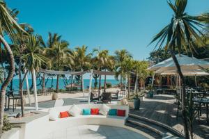 弗利康弗拉克塔马兰高尔夫&Spa精品酒店的一个带沙发和棕榈树的庭院和大海