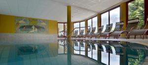 埃尔毛克里斯托夫家庭酒店的大楼内带椅子的游泳池