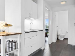 菲耶里茨莱乌Apartment Helemine - 400m from the sea in NW Jutland by Interhome的白色的厨房设有水槽和卫生间
