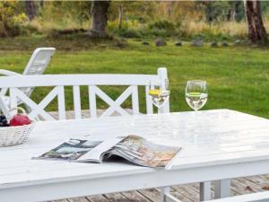 齐斯维勒莱厄Holiday Home Rami - 2km from the sea in Sealand by Interhome的一张带两杯葡萄酒和杂志的白桌