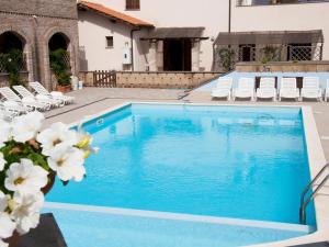 卡波尼费拉Apartment Borgo Valmarina-3 by Interhome的庭院里一个带椅子和鲜花的游泳池