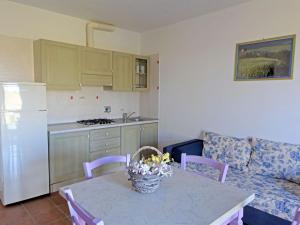 卡波尼费拉Apartment Borgo Valmarina-3 by Interhome的一间带桌子的客厅和一间厨房