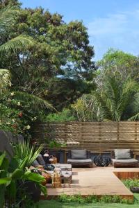 费尔南多 - 迪诺罗尼亚Pousada Maria Bonita Noronha的一个带沙发和桌子的庭院和一个围栏