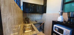 基加利Cozy Nest Oasis - Serviced Apartment的厨房配有水槽和台面上的搅拌机