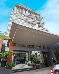 日惹Hotel FortunaGrande Seturan Yogyakarta的一座高大的建筑,前面是商店,