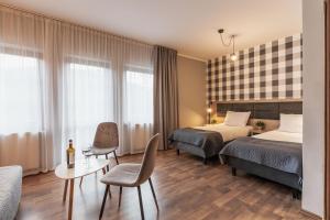 西恩纳Złote Góry的酒店客房设有两张床和一张桌子。