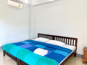 清莱PJ PLACE的一间卧室配有一张带蓝色床罩的床