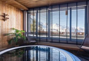 葱仁谷Chalet Carte Blanche Cullinan的客房设有游泳池和大窗户。
