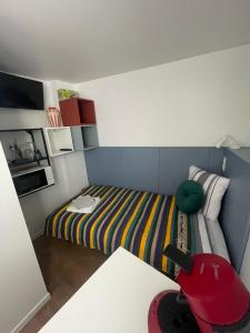 里摩日THEIA Hotel & Suites - Limoges Centre的小房间设有一张床和一张桌子