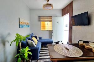 圣地亚哥洛斯卡巴Apartamento acogedor Ashmi的客厅配有蓝色的沙发和桌子